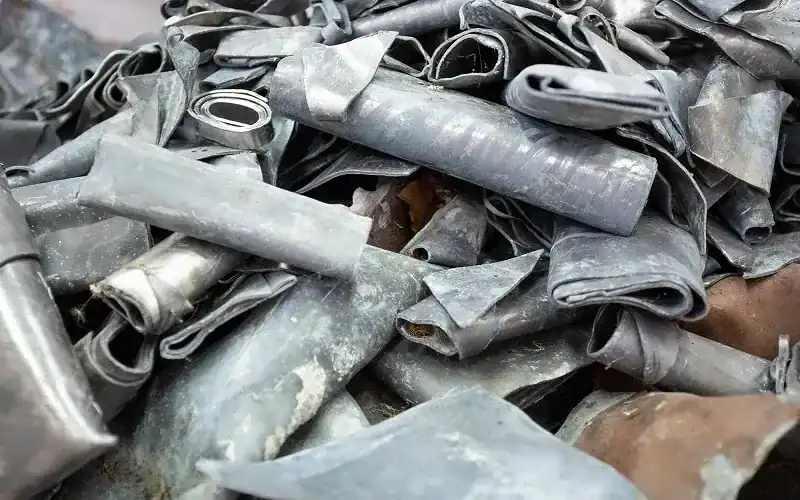 Piles of scrap lead ready for recycling in industrial metal trading.