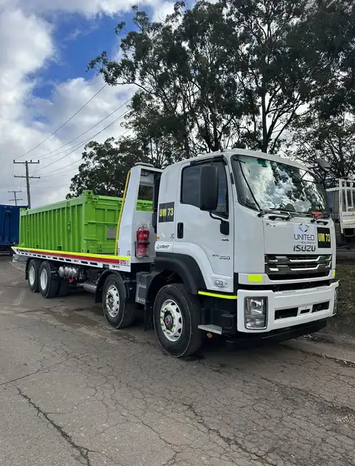 Heavy-duty scrap metal truck with green container for industrial recycling.