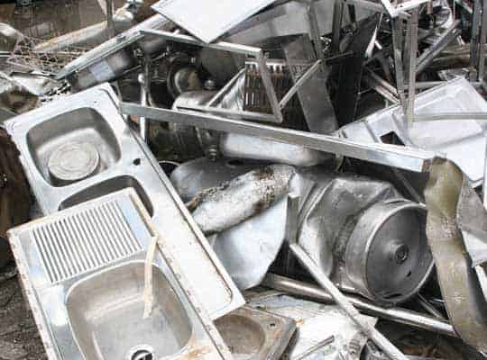 Pile of scrap metal and stainless steel appliances for recycling and metal trading.