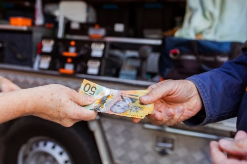 Cash exchange between a customer and trader at United Scrap Metal Traders.