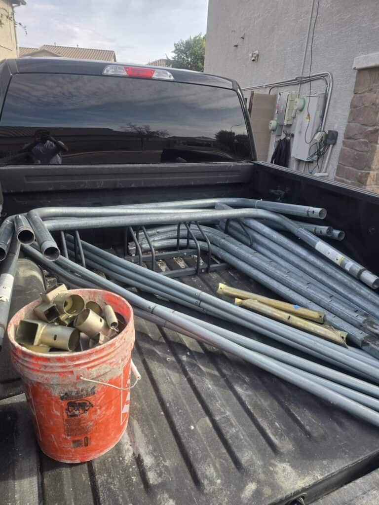 Scrap metal scaffolding and fittings loaded in a truck bed, ready for recycling or disposal.