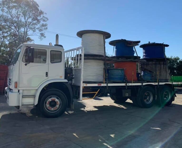 Metal scrap collection truck with spools of wire for recycling services.