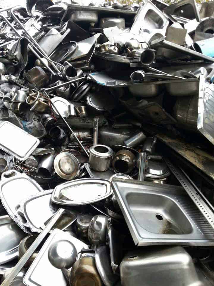 Pile of assorted scrap metal including sinks, pipes, and appliances for recycling.