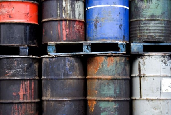 Stacked scrap metal drums in various colors and conditions.
