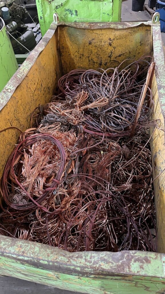 Rusty scrap metal wires in collection bin for recycling.
