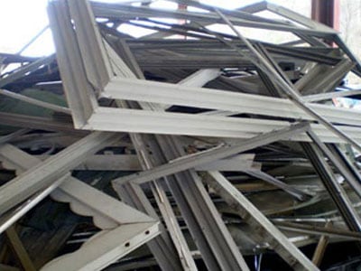 Pile of scrap metal and window frames for recycling and metal trading.