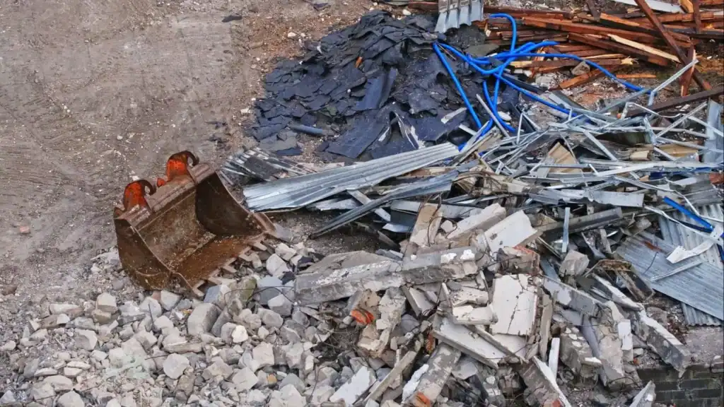 Pile of scrap metal, debris, and construction waste at a metal recycling yard.