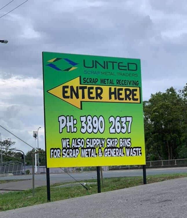 Scrap metal recycling yard entrance sign with contact info and services.